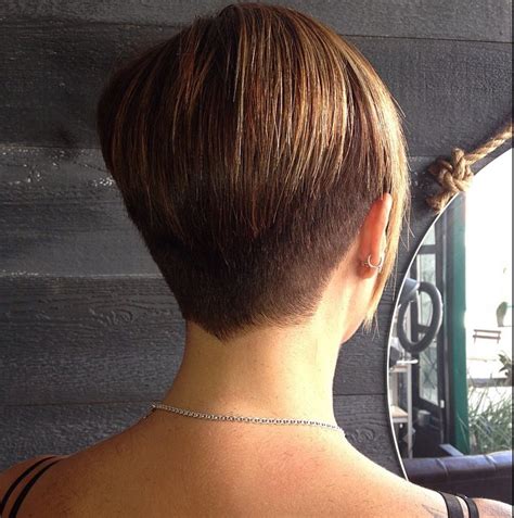 A layered pixie for women with short hair offers a soft, undone finish to the tresses. . Back view pixie short stacked bob